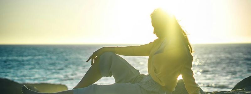 Woman sitting in a meditative posture during golden hour.